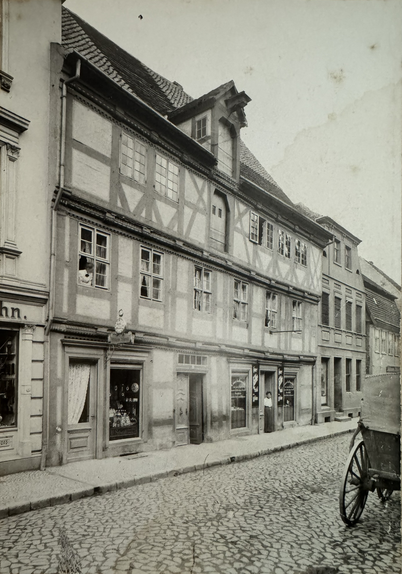 Historisches Foto des Fachwerkhauses mit einer übergroßen Taschenuhr über dem linken Ladeneingang